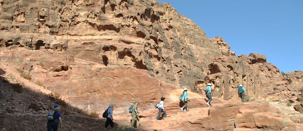 group walking on sandstone path in Petra